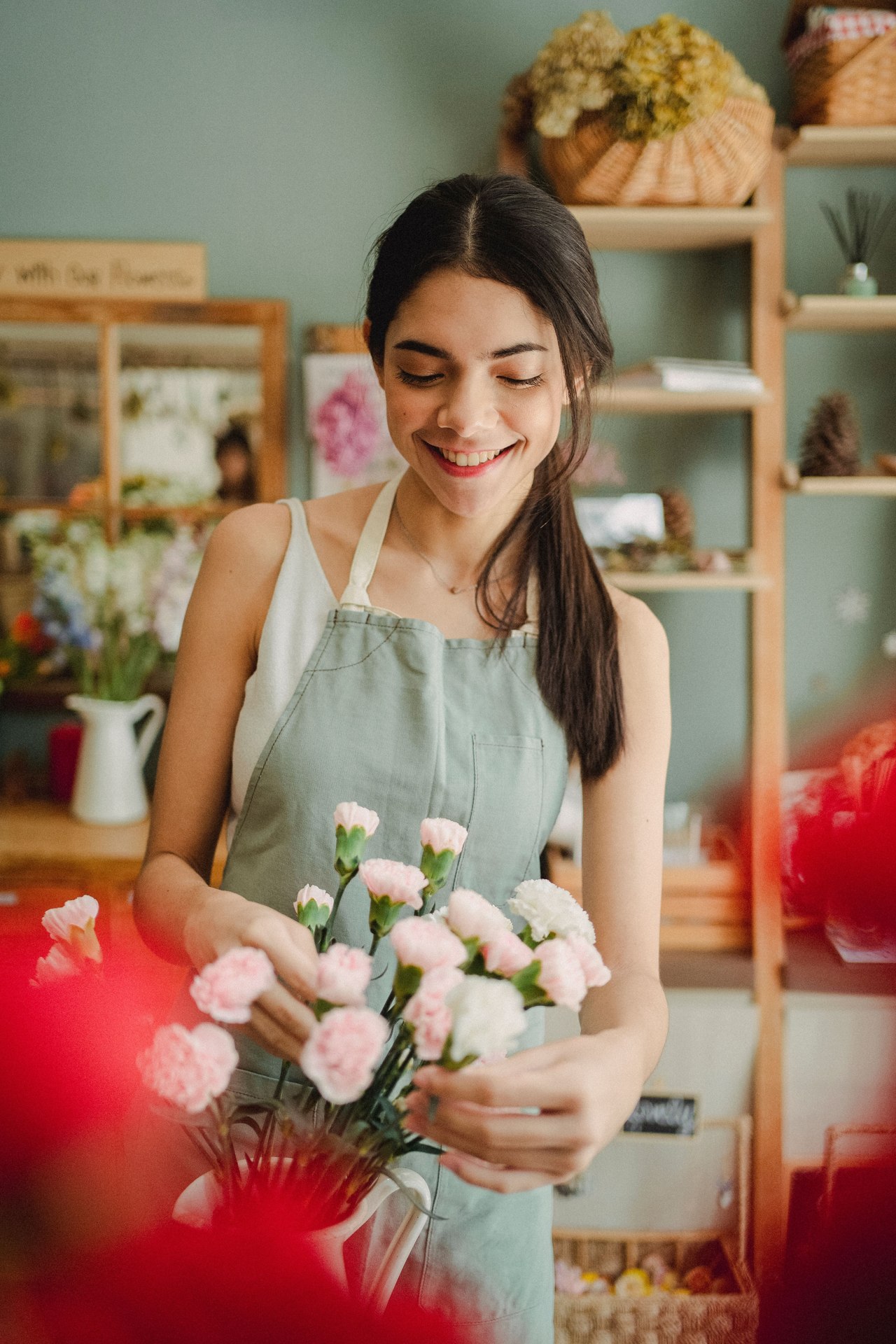 A florist arranging fresh flowers in a plant-filled shop
